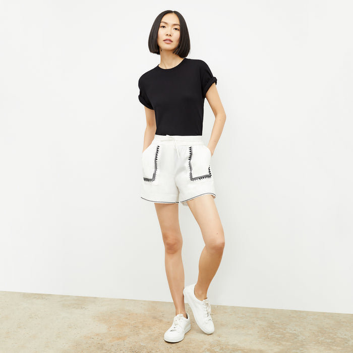 front image of a woman wearing the adina short in white