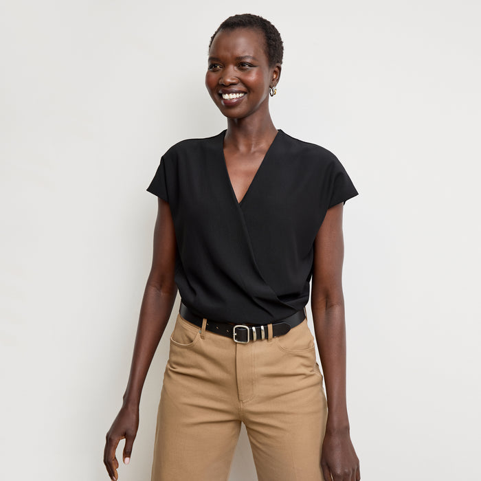 Front image of a woman standing wearing the antonia top soft wave in black | Lead