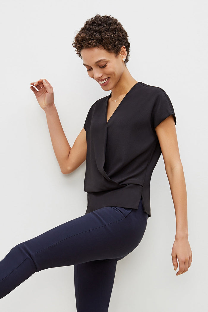 Side image of a woman standing wearing the antonia top soft wave in black | Grid Hover | Exclude