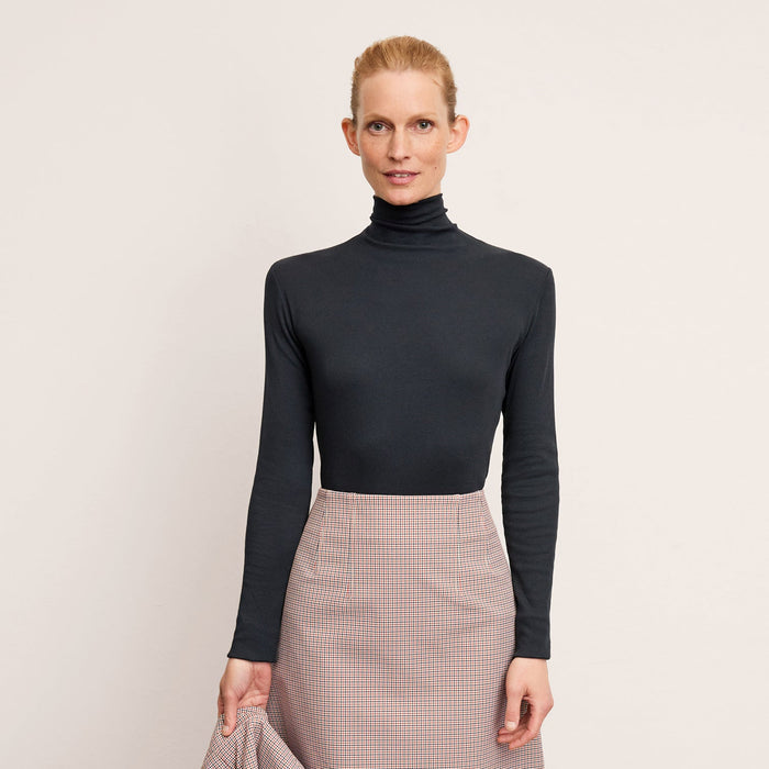 Front image of a woman wearing the axam top in dark navy