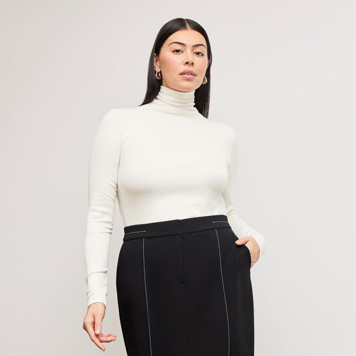 Front image of a woman standing wearing the axam top in ivory | Lead