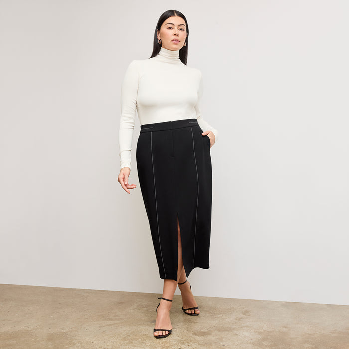 Front image of a woman standing wearing the axam top in ivory | Exclude
