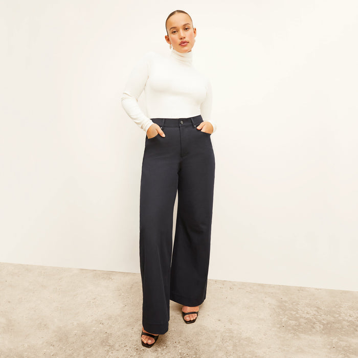 Front image of a woman standing wearing the axam top in ivory