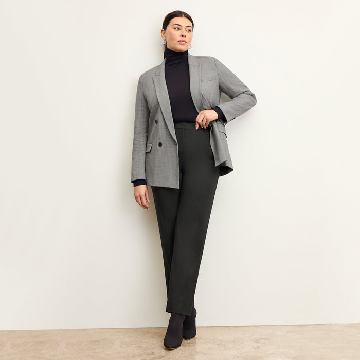 Front image of a woman standing wearing the axam top in black
