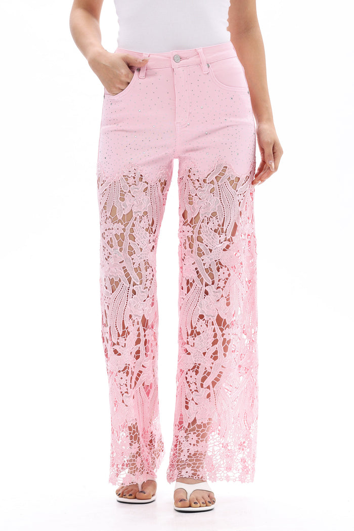 Pink high rise wide leg jeans with floral lace cutout details, rhinestone accents, a natural washed finish, and raw hems.