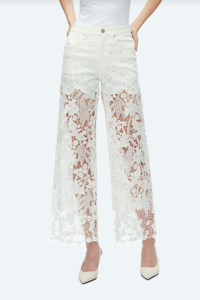 White high rise wide leg jeans with floral lace cutout panels, rhinestone accents, five-pocket styling, and a raw hem.