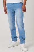 A person wears Beckenham Straight Fit Stretch Denim Jeans in Ice Blue with white sneakers, standing against a plain light background. Only the lower half of the body is visible.
