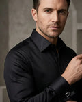 Man wearing a black dress shirt against a neutral background