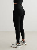 Taka- ja sivunäkymä mallista, jolla on yllään mustat aim'n Shape Seamless Tights -trikoot, joissa on invisible scrunch [S-175cm]