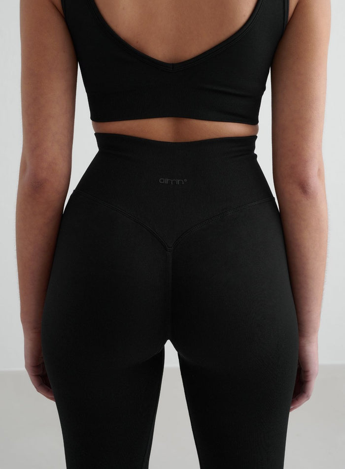 Lähikuva takaa mustista aim'n Shape Seamless Tights -trikoista, joissa on korkea resorillinen vyötärö v-muotoilulla ja invisible scrunch. [S - 175 cm]
