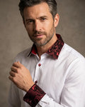 Man wearing a white shirt with red patterned collar and cuffs against a neutral background