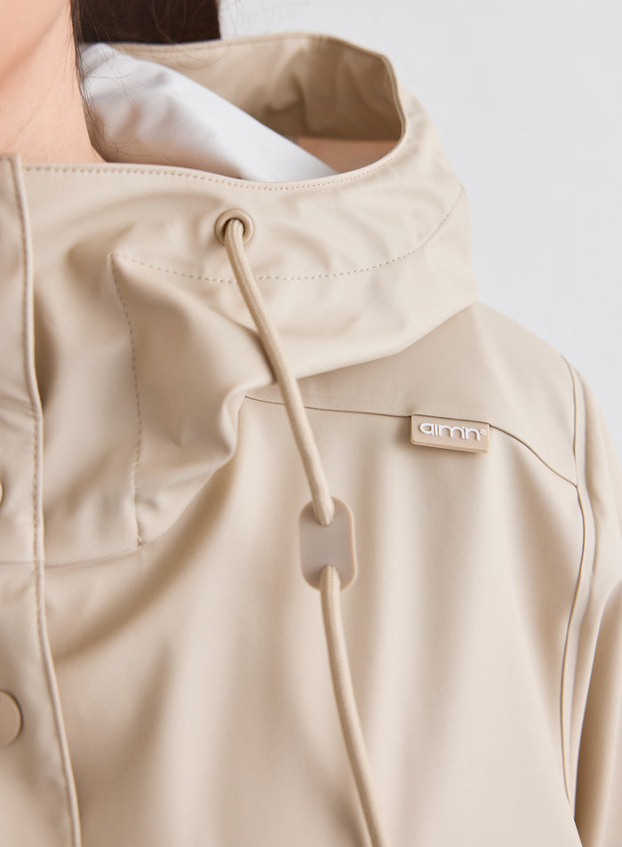 Lähikuva Café Au Lait Rain Jacket -sadetakin hupusta ja logoyksityiskohdasta [M-174cm]