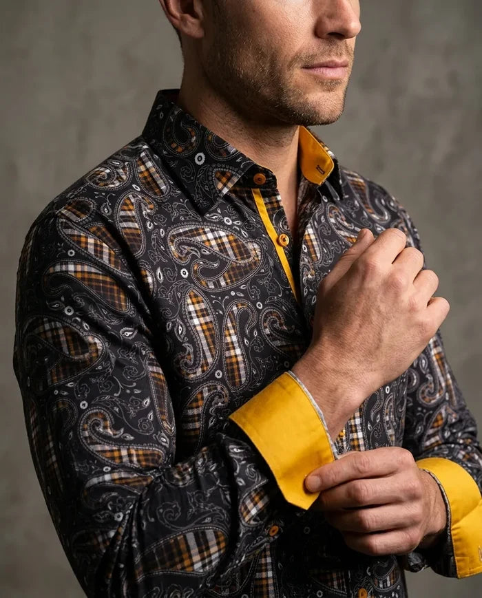 Man wearing a patterned shirt with yellow accents against a gray background