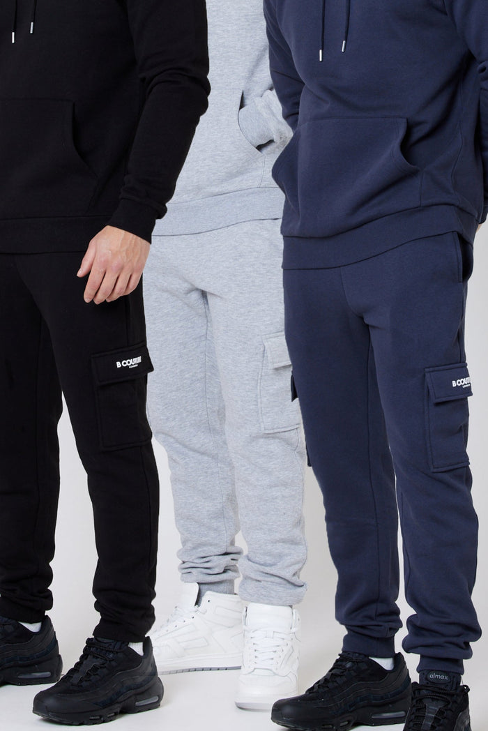 Three pairs of cargo fleece joggers in black, navy, and grey, displayed in a 3-pack format with elasticated waists and cuffed ankles.