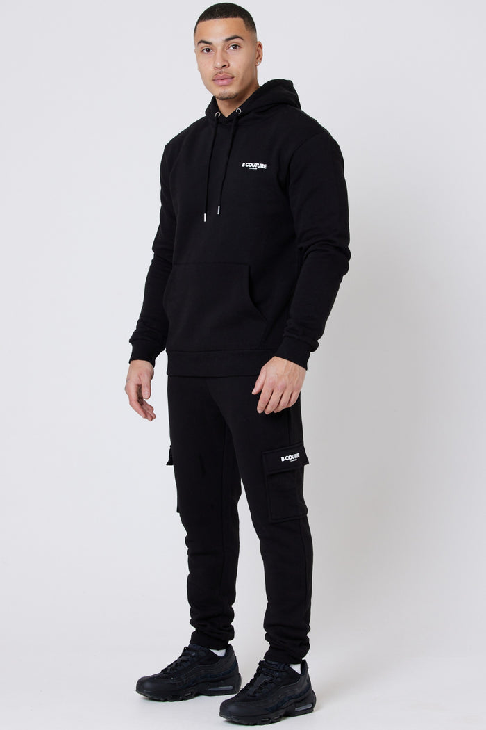 Man wearing black fleece joggers and black fleece hoodie from a multipack