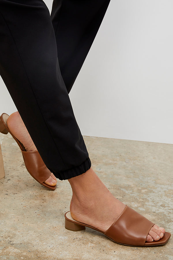 Side image of a woman wearing the Carter Slide - Kidskin in Cognac | Grid Hover | Exclude