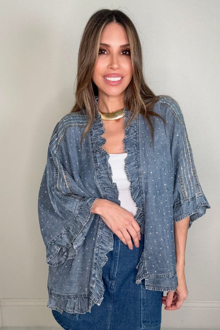 Chambray open-front denim jacket with crystal embellishments, ruffled trim, wide three-quarter sleeves, and shoulder detailing.