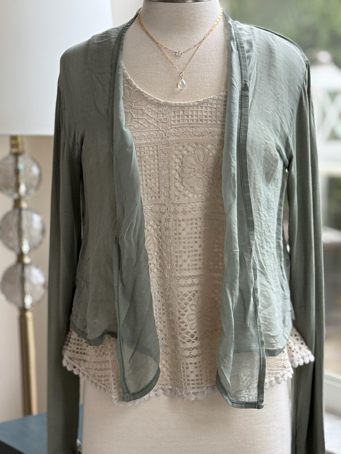 A green olive silk cardigan with a tie-front, displayed on a mannequin with  a necklace.