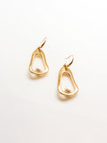 A pair of gold-tone hoop earrings with pearl accents on a white background.