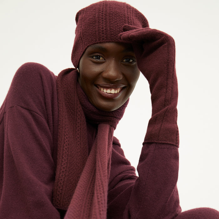 Front image of a woman wearing the Circle Cable Beanie in Chianti