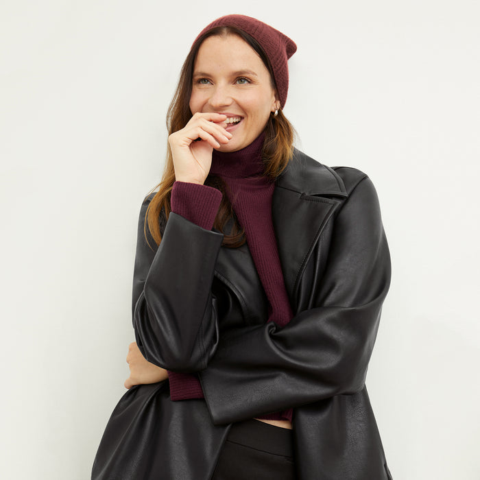 Front image of a woman wearing the Circle Cable Beanie in Chianti