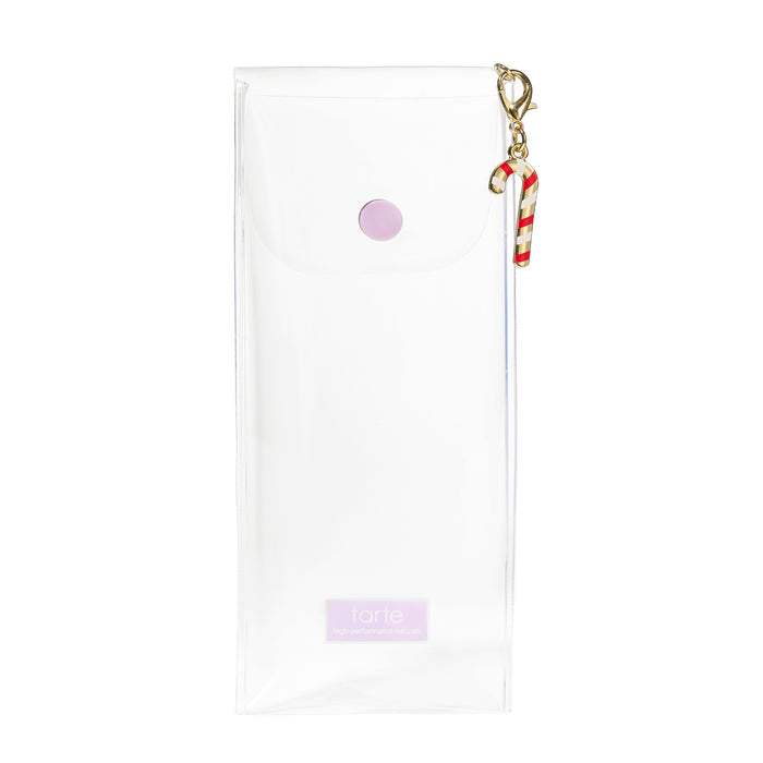 A clear plastic pouch with a white interior, a small light purple snap button, a lavender brand label at the bottom, and a gold clasp holding a red-and-white striped candy cane charm, shown on a white background.