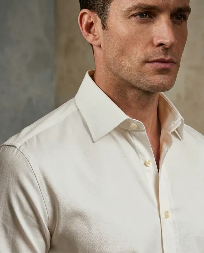 Man wearing a light-colored dress shirt against a neutral background
