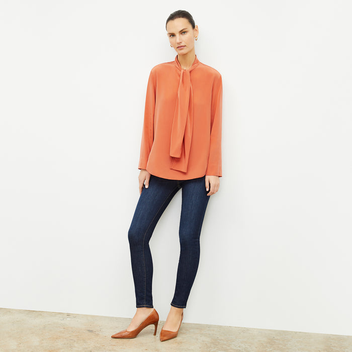 Front image of a woman wearing the Darcy Top in Guava | Lead