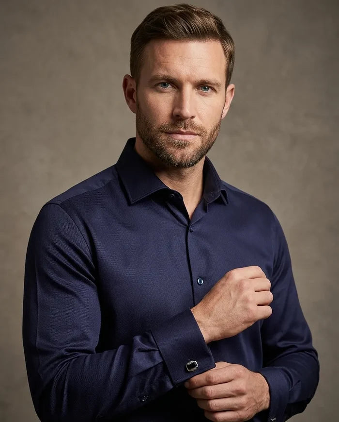 Man wearing a navy blue shirt against a brown background