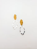 A pair of elongated hoop earrings with a hammered finish, featuring gold and silver colors.