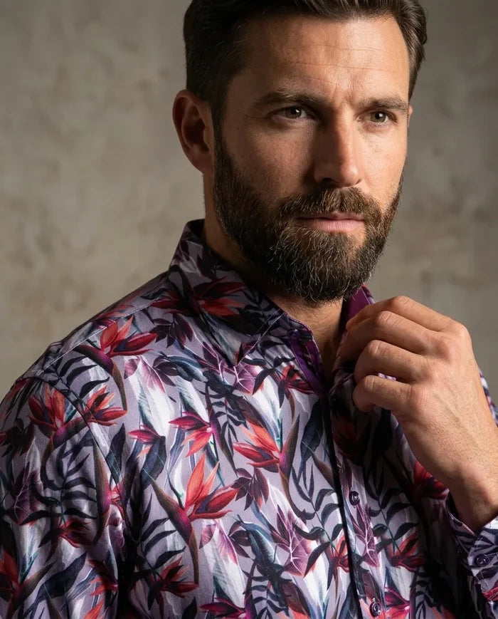 Man wearing a colorful floral shirt against a neutral background
