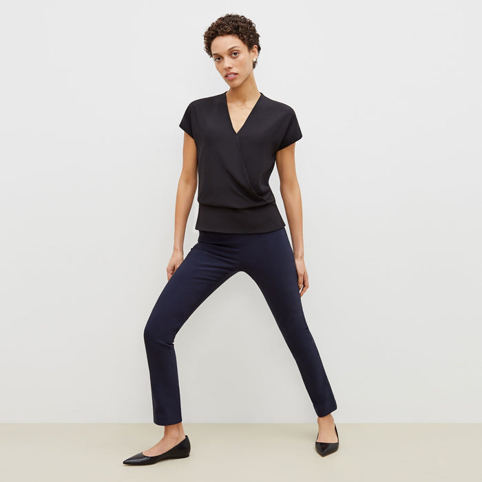 Front image of a woman standing wearing the foster pant in dark navy