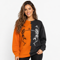 Woman wearing orange and black Halloween skeleton sweatshirt with dancing skeleton print on a clean white studio background.