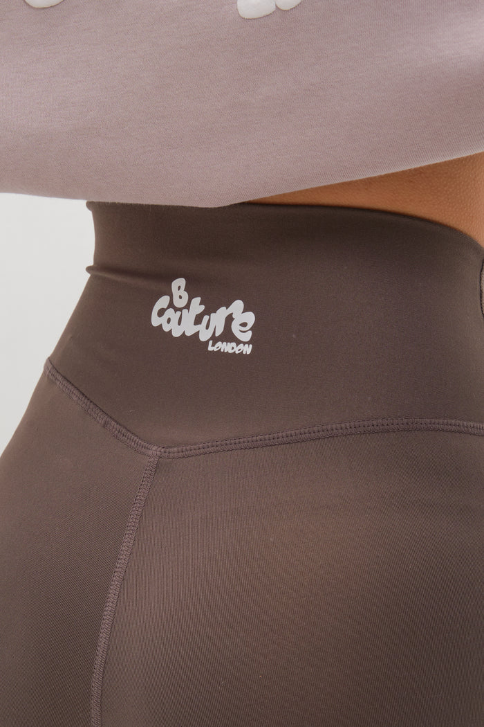 Close-up of the Hatherley Half-Zip Sweatshirt & Leggings Set in Stone, featuring high-waisted leggings with a white B Couture London logo and a cosy sweatshirt peeking out for a stylish, comfortable look.