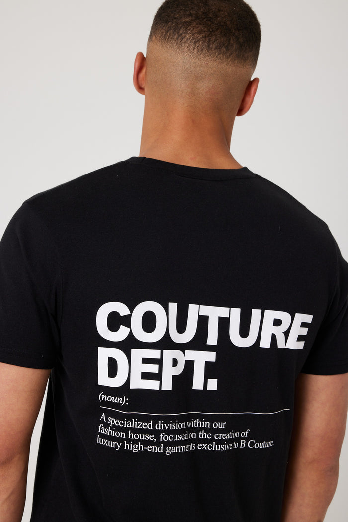A man facing away from the camera wears the Haydon Walk Regular Fit Cotton T-Shirt in black/white, featuring large white “COUTURE DEPT.” text and a definition on the back—a versatile men's wardrobe staple.