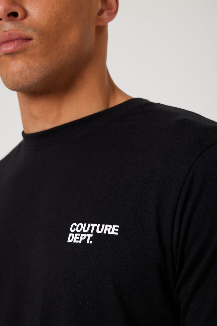 A man wears the Haydon Walk Regular Fit Cotton T-Shirt in black with "COUTURE DEPT." printed in white on the chest, showcasing this versatile men's cotton tee against a plain background.