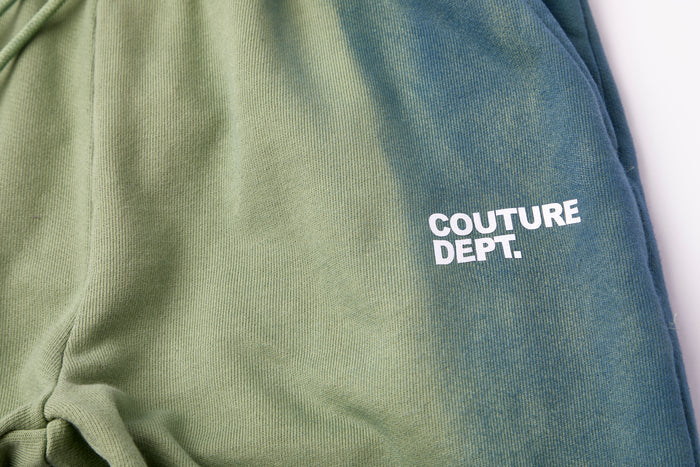 Close-up of green Heavy Weight Oversized Couture Department Joggers with bold white COUTURE DEPT. print on the side. The soft, textured fabric adds a premium touch to these heavyweight joggers.