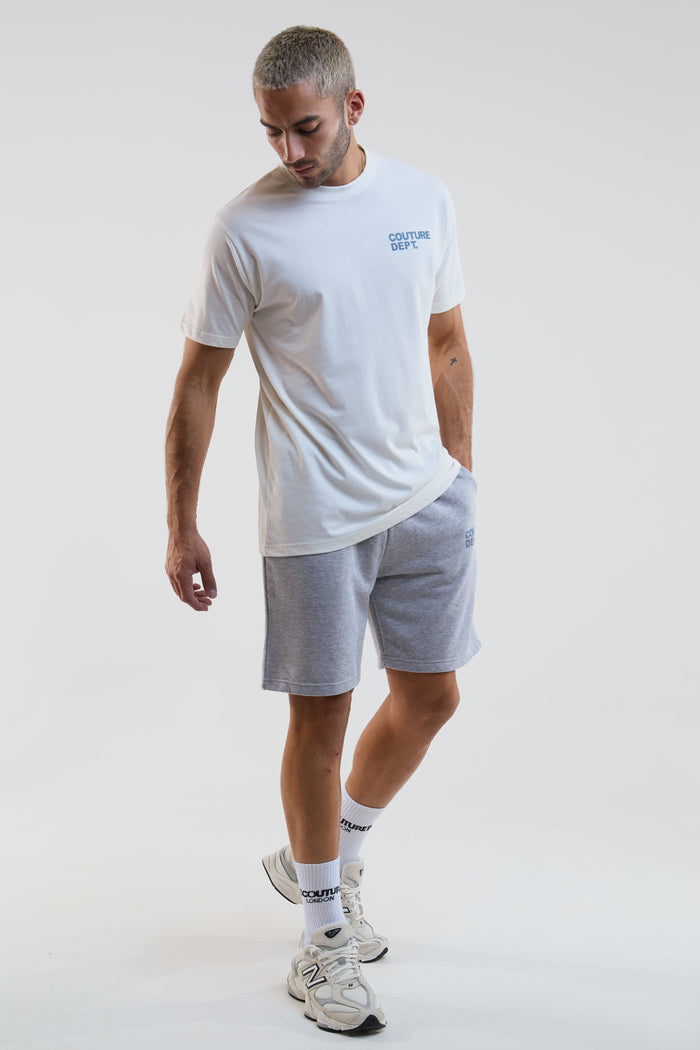 Man wearing a white t-shirt and gray shorts on a plain background