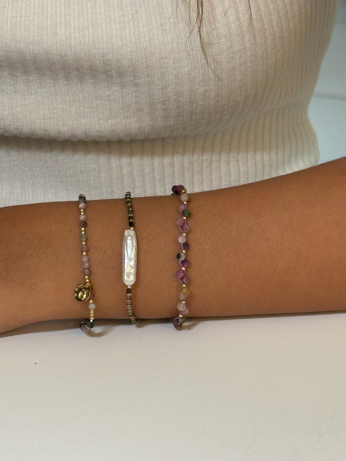 Close-up of a wrist wearing multiple beaded bracelets on a model