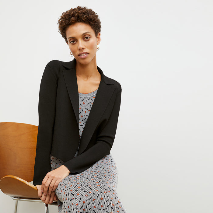 Front image of a woman sitting wearing the Jolie Jardigan in Black