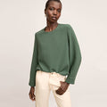front image of a woman wearing the jules top in dusty pine | Lead