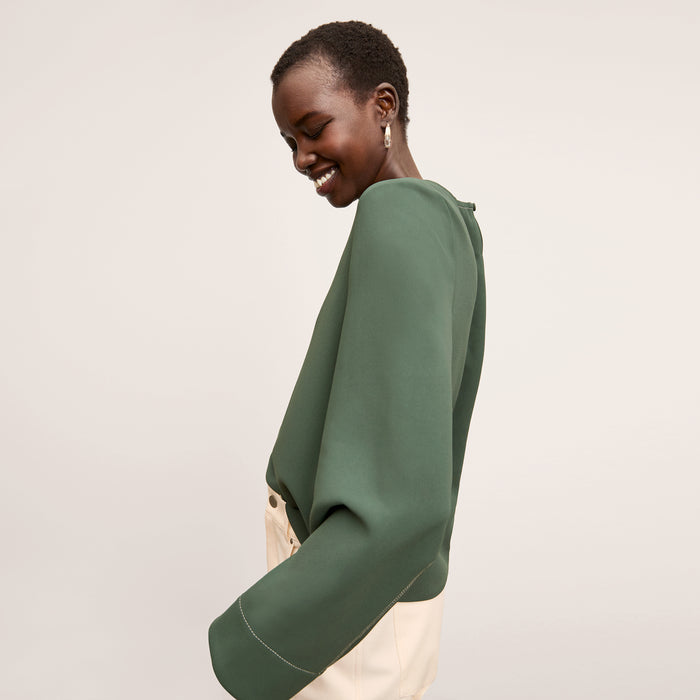side image of a woman wearing the jules top in dusty pine
