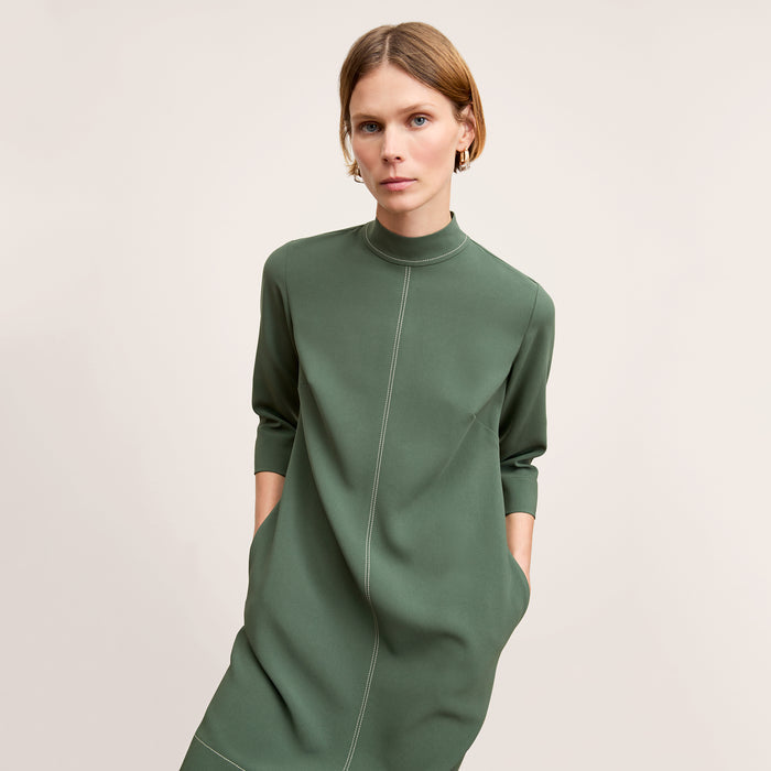 front image of a woman wearing the kinsley dress in dusty pine