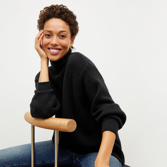 Front image of a woman wearing the lea sweater in black