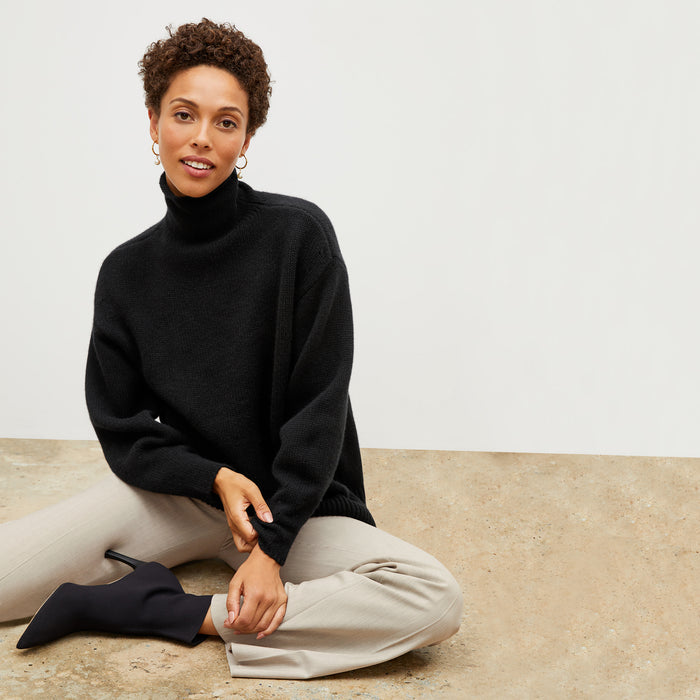 Front image of a woman wearing the lea sweater in black