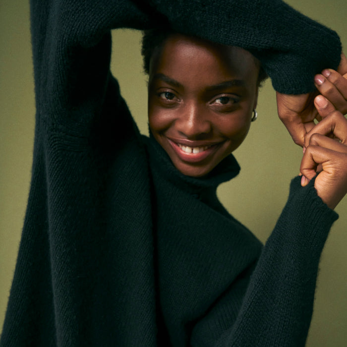 Front image of a woman wearing the lea sweater in black