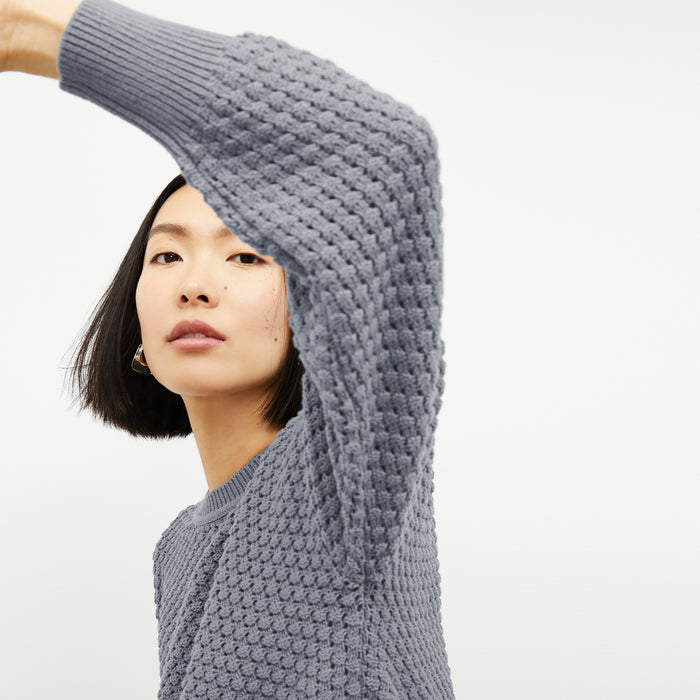 front image of a woman wearing the liam sweater in flint gray