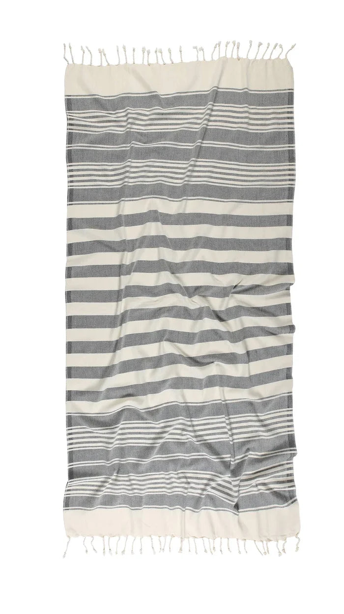 A striped beach towel in gray and white, with fringed edges.
