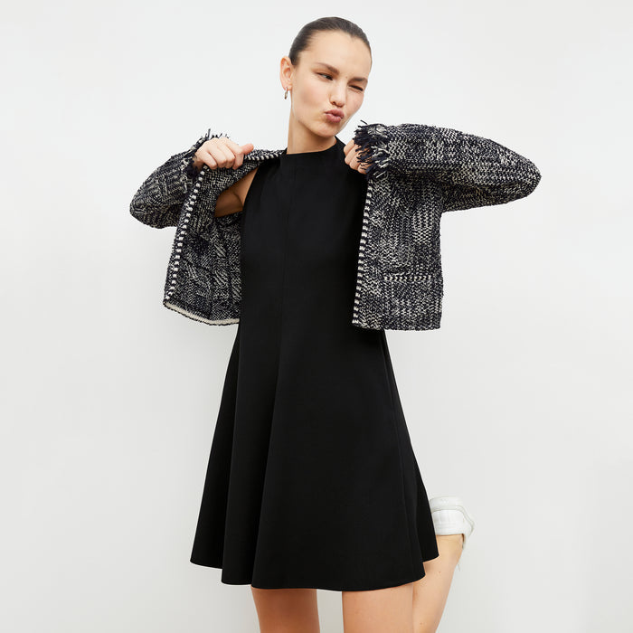 Front image of a woman in the malala dress in black