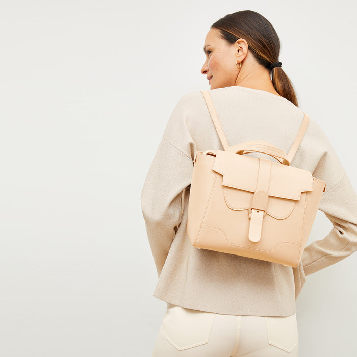 Image of a woman wearing the M.M.LaFleur x SENREVE Maestra Belt Bag in Chablis